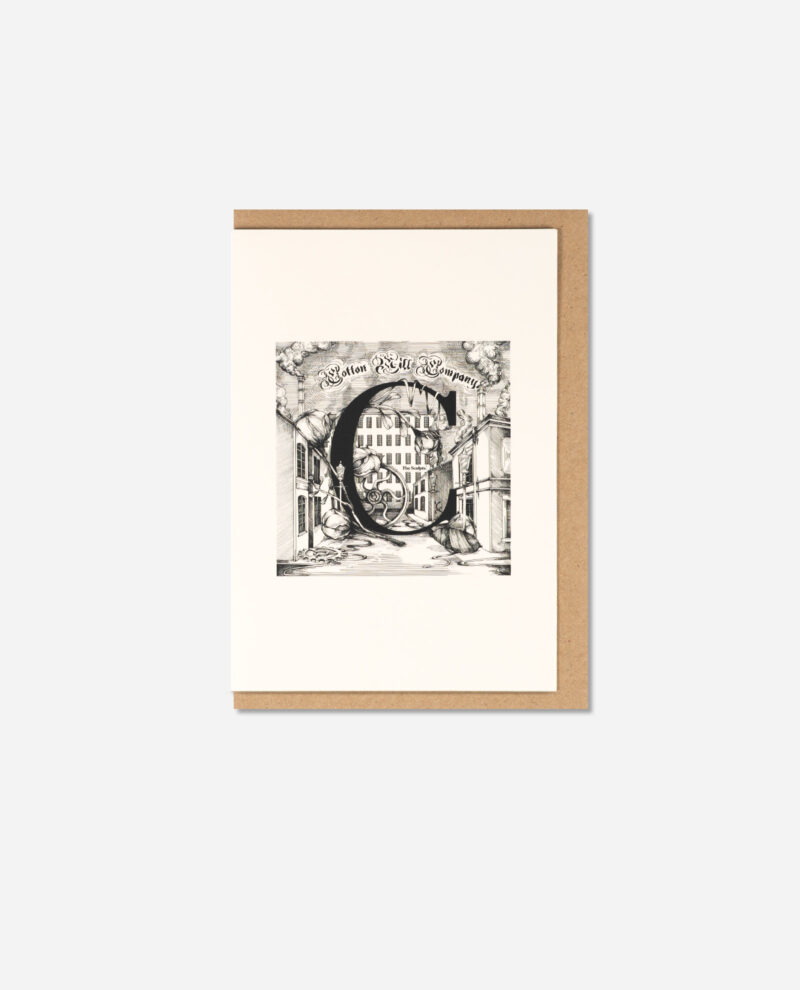 Overhead view of The Manchester Letters C for Cottonopolis greeting card on kraft brown envelope showing vintage illustration