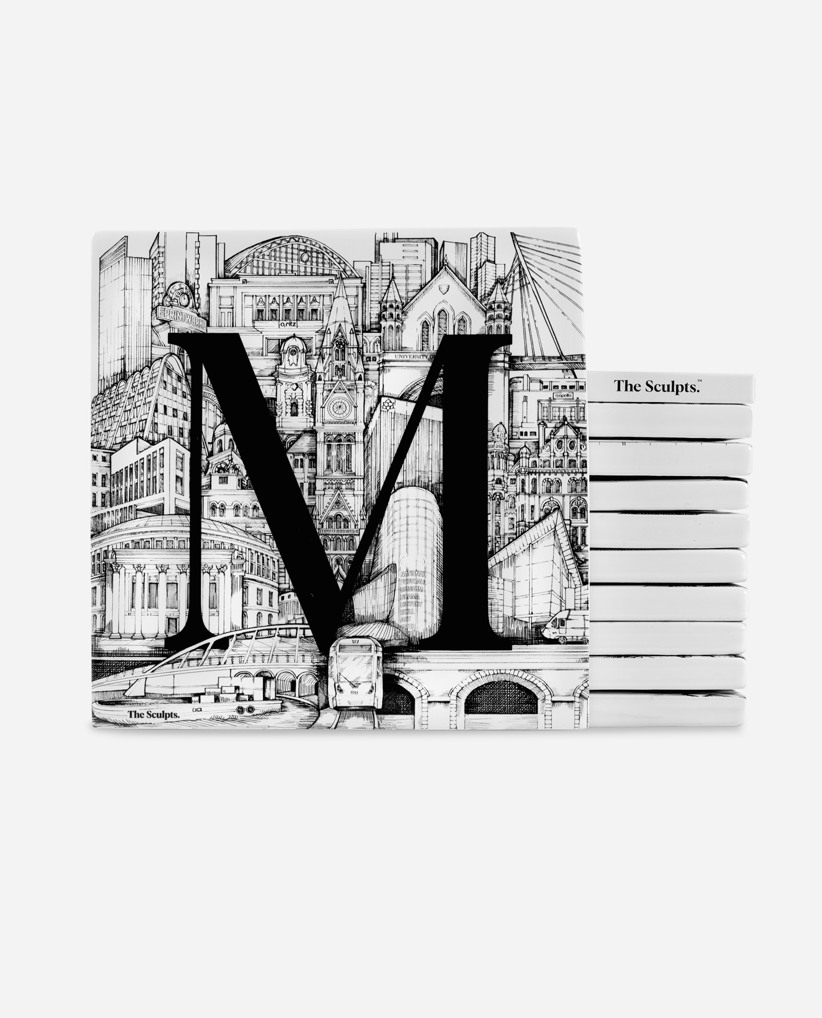 The Manchester Tile Set white ceramic tiles stacked showing large black M letter over detailed pen illustration of Manchester buildings