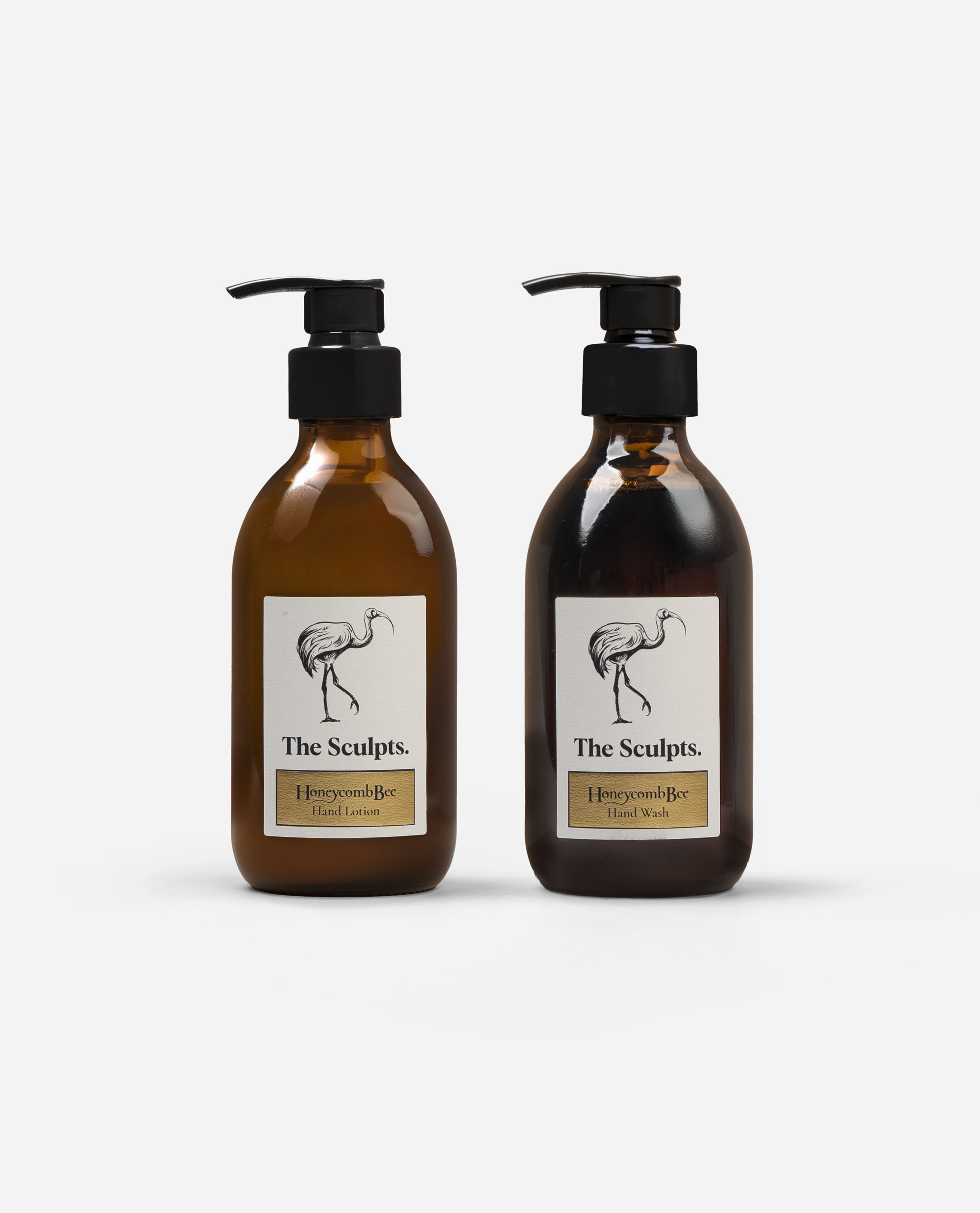 Honeycomb Bee hand wash and lotion set in amber glass bottles with black pumps and cream labels featuring bird illustration